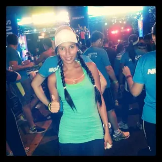 Oriana en sus años de corredora, sonriendo con el pulgar arriba en una carrera nocturna